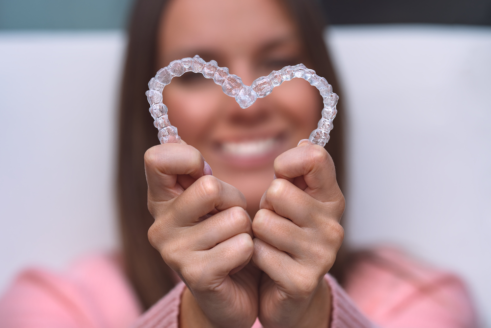 A woman smiles after figuring out how how invisalign works.