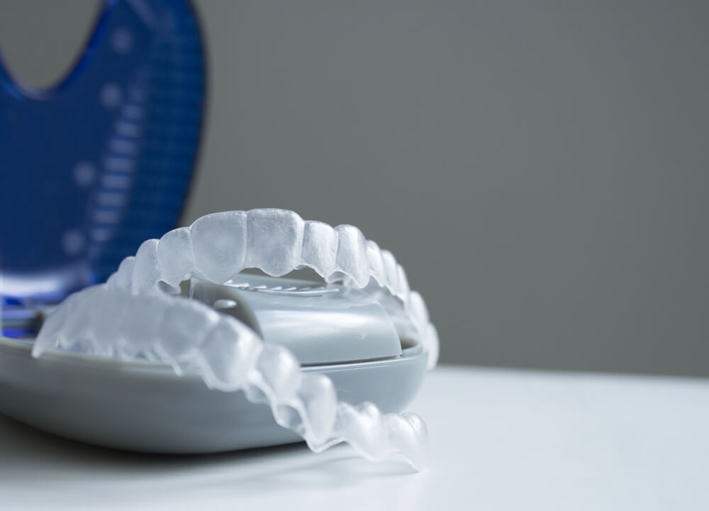 A closeup of two Invisalign aligners on a case, like those used in Invisalign treatment in San Tan Valley AZ.